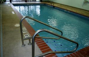 uma piscina com um corrimão de metal na água em Evergreen Inn & Suites em Monroe
