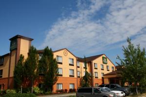 a hotel with cars parked in front of it at Evergreen Inn & Suites in Monroe