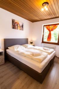 ein großes Bett in einem Zimmer mit Fenster in der Unterkunft Metzgerwirt Vieh Heli in Bad Goisern