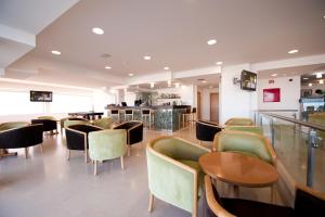 a restaurant with chairs and tables and a bar at Hotel Mar e Sol & Spa in São Pedro de Moel