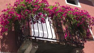 einen Balkon mit rosa Blumen auf einem rosa Gebäude in der Unterkunft La Casa del Colonnello in Vercelli