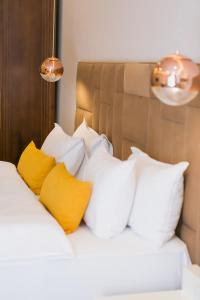 ein Bett mit weißen und gelben Kissen darauf in der Unterkunft Kazakhstan Hotel in Almaty