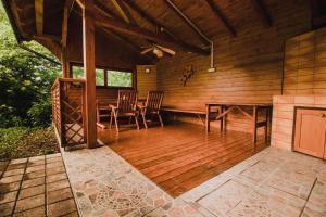 a large deck with a table and chairs in a cabin at Lazec Country House in Plužnje