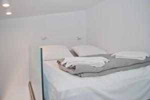a white bed with white sheets and pillows at Christina Beach Hotel in Chania Town