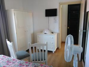 Pokój ze stołem, 2 krzesłami i komodą w obiekcie Pensao Residencial Vila Teresinha w Funchal