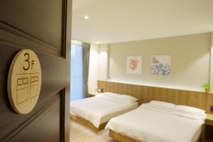 1 dormitorio con 2 camas y una tabla de surf en la pared en Ecology River, en Dongshan