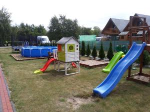 einen Spielplatz mit Rutsche und Spielstruktur in der Unterkunft Ow Bursztynek in Rusinowo