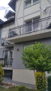 a white building with a balcony with a staircase at Ostrowianka in Ostrowo