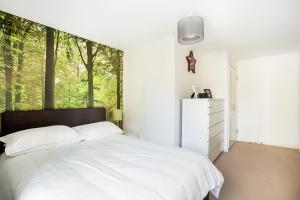 a bedroom with a white bed with a large window at Beautiful, Secure, 2-bedroom Canal-side Apartment in London