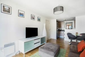 a living room with a tv and a couch at Beautiful, Secure, 2-bedroom Canal-side Apartment in London