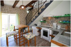 cocina con mesa y fogones horno superior en Makol en Primošten