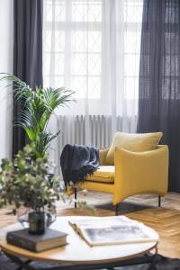 sala de estar con sofá amarillo y mesa en Lazenska N4 Residence, en Praga