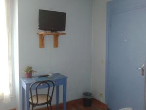 a room with a blue table and a television on a wall at Annapolis in Aix-les-Bains