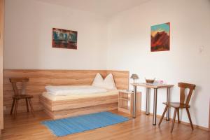 a bedroom with a bed and two chairs and a table at Pension Post - Sistrans in Innsbruck