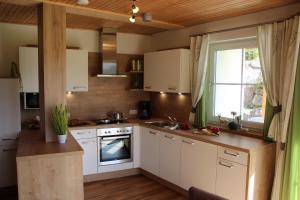 a kitchen with white cabinets and a sink and a window at Am Schwand in Grän