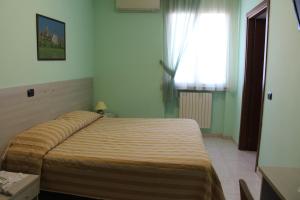 sypialnia z łóżkiem w pokoju z oknem w obiekcie Hotel Certosa w mieście Certosa di Pavia