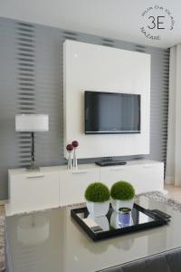 a living room with a tv and two plants on a table at Rooftop sea view with private swimming pool in Nazaré