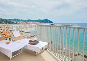 a balcony with two chairs and a view of the ocean at Hotel Corallo in Imperia