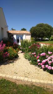 a garden of flowers in front of a house at La campagne a la mer in Piédemont