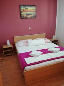 1 dormitorio con 1 cama grande y pared morada en Apartments Katarina 2, en Makarska