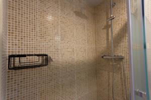 ラメトリャ・デ・マールにあるINNOUTHOME Apartamento Ramón y Cajal IIのバスルーム(茶色のタイル張りの壁のシャワー付)