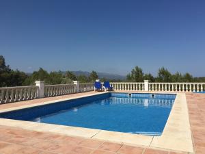 a swimming pool with two chairs and a fence at Casa Olivo in Perelló