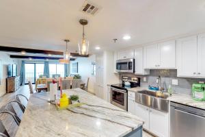 a kitchen with white cabinets and a large counter top at Surf Dweller #306 in Fort Walton Beach