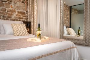 - une chambre avec un lit avec un miroir et une bouteille de vin dans l'établissement Ziggy Star in Diocletian Palace, à Split