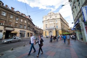 two men walking down a street in a city at President Apartment in Sarajevo