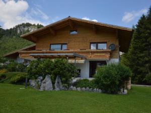 a log house with a green lawn in front of it at Apartment in W ngle Tyrol with Walking Trails Near in Reutte