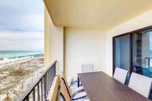a balcony with a table and chairs and the beach at Surf Dweller #306 in Fort Walton Beach