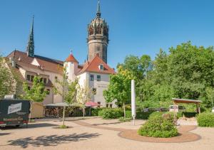 a building with a clock tower in a park at Hotel Alte Canzley in Lutherstadt Wittenberg