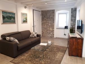 un soggiorno con divano marrone e finestra di Casadina a Monte Isola