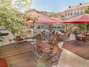 eine Außenterrasse mit Tischen, Stühlen und Sonnenschirmen in der Unterkunft Hotel Alte Canzley in Lutherstadt Wittenberg