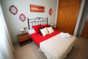 ロケタス・デ・マルにあるExpoholidays - Parque Salinasのベッドルーム1室(大型ベッド1台、赤と白の枕付)
