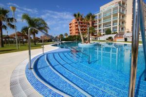 einen Pool in einem Resort mit Palmen in der Unterkunft Expoholidays - Parque Salinas in Roquetas de Mar