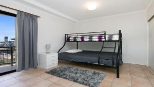 a bedroom with a bunk bed and a window at Heritage Pines Apartment by Kingscliff Accommodation in Kingscliff
