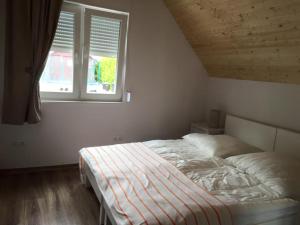 - un lit dans une chambre avec fenêtre dans l'établissement Apartamenty Beata Wisełka, à Wisełka