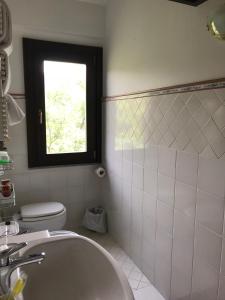 a bathroom with a sink and a toilet and a window at Residenza Le Serre in Acciaroli