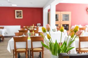 un comedor con mesas, sillas y flores en Hotel Jägerhaus, en Singen