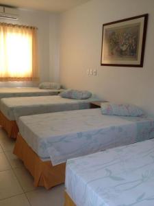 a group of four beds in a room at Hotel Icaro in Foz do Iguaçu