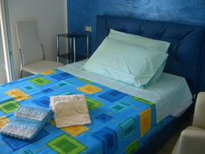a bed with a colorful quilt on top of it at S'OLIVARIU VILLAGE affittacamere B&B PARADISE PISCINAS in Piscinas