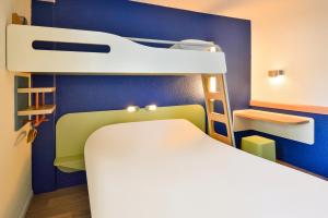 a small room with a bed and a lamp at Ibis budget Chambéry Centre Ville in Chambéry