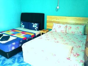 a bedroom with two beds and a bedskirts at Rainbow Tioman Cottage in Kampong Juara