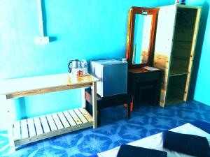 a blue room with a table and a mirror at Rainbow Tioman Cottage in Kampong Juara
