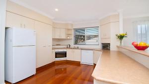 a kitchen with white appliances and a white refrigerator at Orient Lane on the Hill by Kingscliff Accommodation in Kingscliff