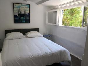 una camera con un letto bianco e una finestra di La petite maison de Lingling a Mornas