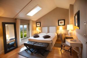 a bedroom with a bed and a desk and a window at Relais Villa D'Amelia in Benevello