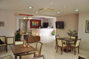 una sala da pranzo con tavoli e sedie e una cucina di Ostria Hotel a Paleocastro (Palekastron)
