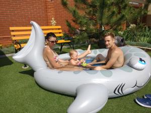 two men and a baby in an inflatable pool at Kosmos 519 in Zatoka